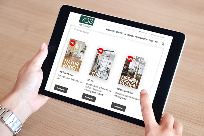 Person nutzt Tablet, um im Onlineshop von Voß Holzhandel durch die HQ-Produkte wie Naturboden, Türen und Designboden zu stöbern.