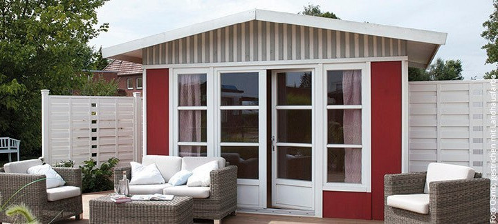 Gartenhaus mit angrenzender Terrasse, ausgestattet mit Gartenmöbeln, umgeben von einem grünen Garten.