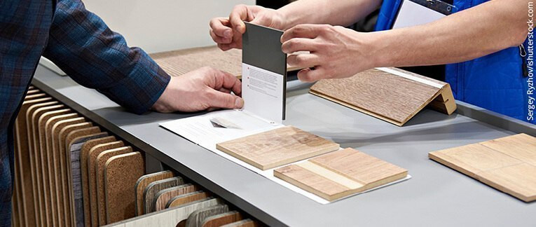 Kundenberatung im Fachhandel: Zwei Personen begutachten verschiedene Materialmuster für Bodenbeläge.