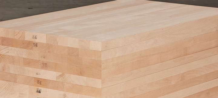 Gestapelte Massivholzplatten mit durchgehenden Lamellen, ideal für den Möbel- und Innenausbau.