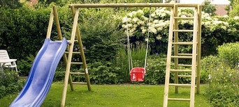 Spielgeräte: Schaukel und Rutsche für Kinder im Garten.