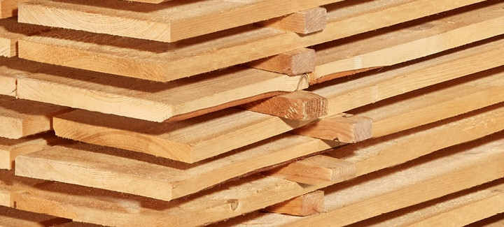 Gestapelte Schalbretter aus Holz mit sägerauer Oberfläche, ideal für den Bau- und Konstruktionsbereich.